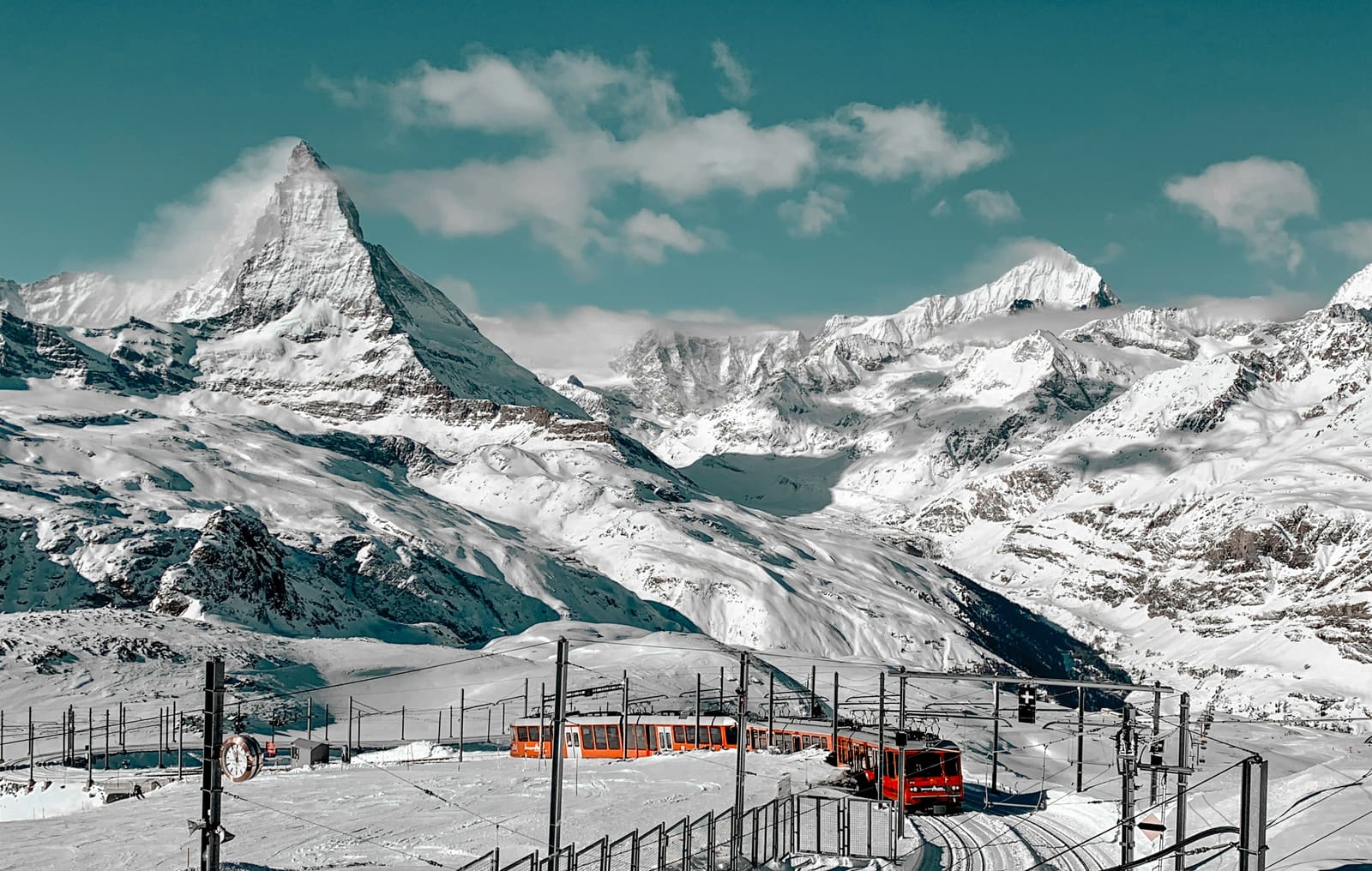 Das Matterhorn mit einer roten Zahnradbahn in tief verschneiter Landschaft